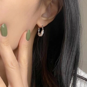 Boucles d'oreilles créoles torsadées en argent sterling S925 sur le profil d'une femme