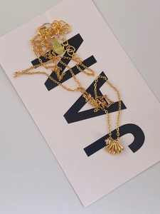 Gros plan du poinçon S925 sur le collier pendentif coquillage doré orné de zircon