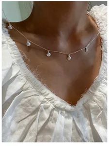 Detail shot of a S925 sterling silver choker necklace featuring five small shell pendants