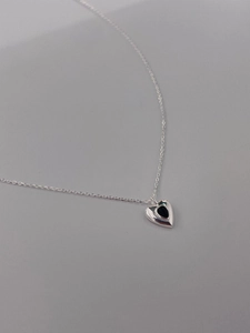 Macro shot of 925 silver necklace featuring a black heart-shaped onyx pendant detail
