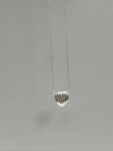 Minimalist 925 sterling silver heart necklace with vertical striped texture on grey background
