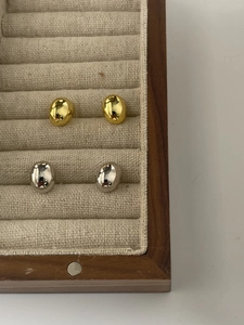 Detail view of oval polished 925 silver stud earrings in gold and silver finishes