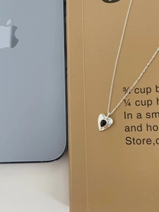 Detail of 925 sterling silver heart necklace with black inlay on lifestyle background