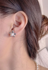 925 silver pearl flower stud earrings with vintage texture on a model's ear