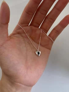 Close-up of 925 sterling silver heart necklace featuring a black teardrop gemstone pendant