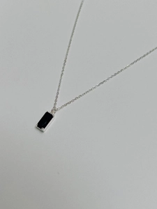 Gros plan sur un collier en argent 925 avec pendentif en pierre précieuse noire rectangulaire