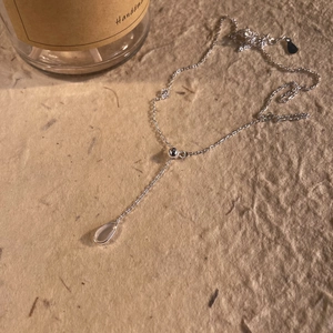 Minimalist 925 sterling silver water drop pendant necklace on a natural kraft paper