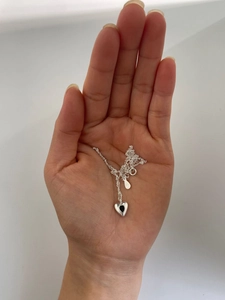 S925 sterling silver heart necklace with black agate pendant held in hand for scale
