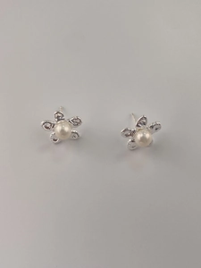 Macro detail of 925 silver flower stud earrings with a central white pearl inlay