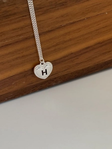Detaillierte Makroansicht der 925er Sterlingsilber Herz-Halskette mit graviertem Buchstaben H