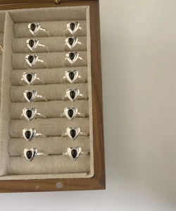 Detailed macro view of multiple S925 sterling silver rings with black heart-shaped gemstones