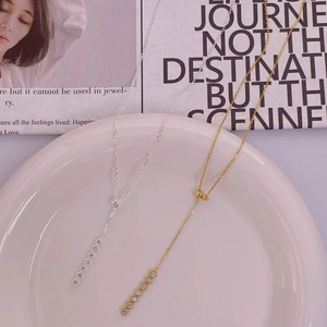 Detailed view of silver and gold Y-shaped necklaces with vertical diamond row pendants