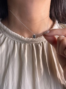 925 silver heart necklace with black gemstone pendant worn on model neck