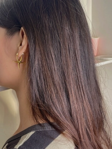 Detailed view of polished gold starfish earrings worn for a modern stylish look