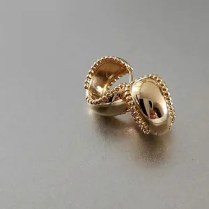 Vintage golden wide hoop earrings with beaded edges and polished metallic finish