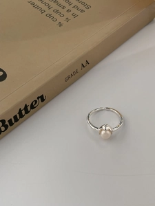 Détail macro d'une bague en argent 925 avec perle naturelle et texture martelée