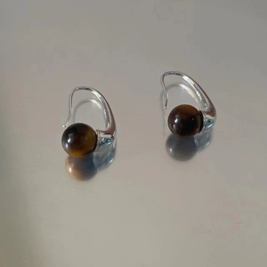 Detail of S925 sterling silver hooks and brown tiger eye stone beads on earrings