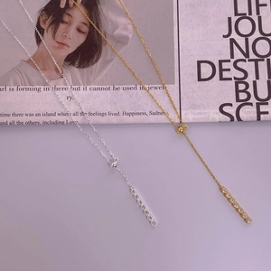 Detail of adjustable S925 silver and 18K gold Y-necklace with elegant CZ bar pendants