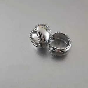 Macro shot of silver metal hoop earrings with delicate beaded edge and latch closure
