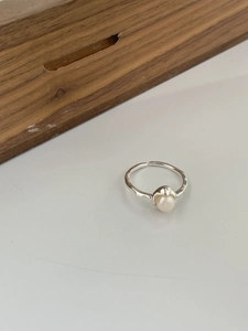Détail macro d'une bague ouverte en argent 925 ornée d'une perle naturelle blanche