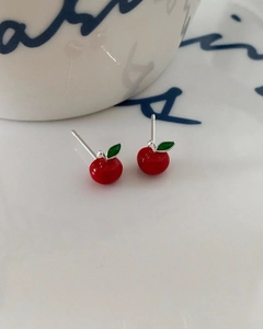 Close-up of 925 sterling silver cherry stud earrings with red enamel and green leaf