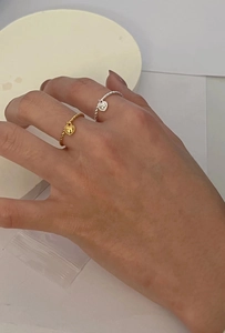 Detail of twisted 925 silver and gold heart pendant rings worn on fingers