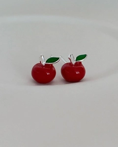 Macro shot of 925 sterling silver apple stud earrings with red glaze and green leaf