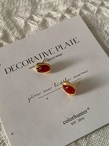 Vue macro détaillée de boucles d'oreilles carrées en or vintage avec incrustation ambre rouge