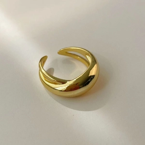 Detailed macro view of a minimalist golden wide dome ring with polished surface