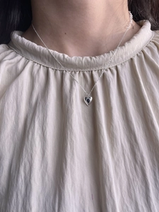 Close-up of S925 sterling silver necklace with a heart-shaped black onyx pendant on model