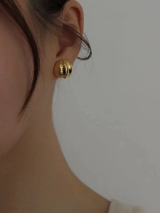 Detailed view of gold 925 sterling silver stud earring with textured pumpkin design