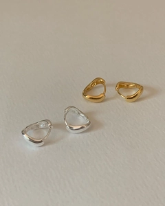 Detail view of organic irregular round earrings in polished gold and silver finishes