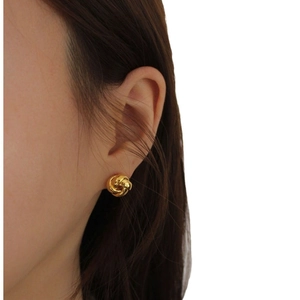 Minimalist 925 sterling silver gold knotted stud earrings worn by a model on white background