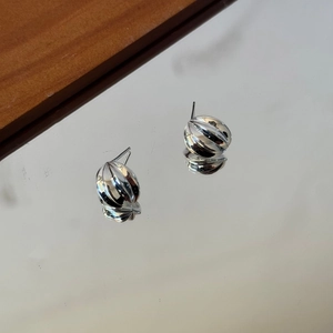 Macro shot of 925 sterling silver stud earrings with ribbed spherical design and mirrored finish