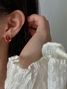 Boucles d'oreilles minimalistes carrées en pierre rouge et cadre doré sur modèle