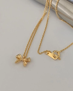 Elegant gold bow pendant necklace with slim O-chain and polished metal finish for women