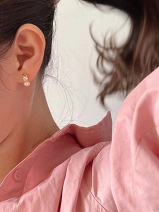 Close-up of S925 silver pearl stud earring with zircon on a model's ear