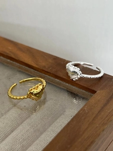 Detail of S925 sterling silver heart rings with beaded bands in gold and silver