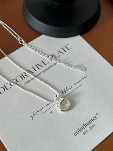 Detail of S925 sterling silver chain with double ring pendant on display card
