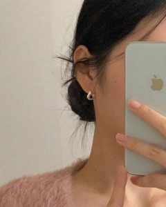Detail of 925 sterling silver waterdrop hoop earrings worn with a pink mohair sweater