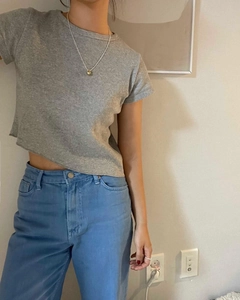 Model wearing a French style 925 sterling silver ball pendant necklace with a grey crop top