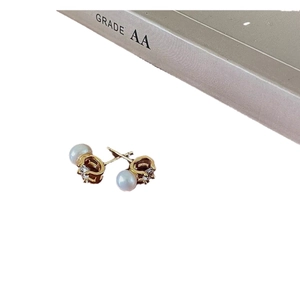 Elegant C-shaped gold-plated pearl and zircon stud earrings for women on a display