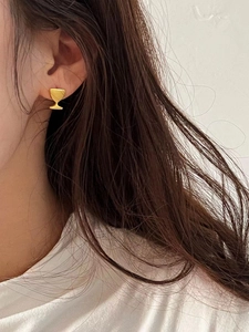 Orecchino a perno a forma di calice in argento S925 dorato opaco su modella