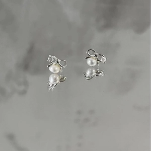Elegant S925 sterling silver bow earrings with pearls and cubic zirconia on reflection