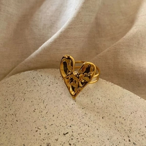 Macro detail of 18K gold plated heart ring featuring unique hammered lava texture