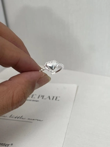 Macro detail of S925 sterling silver heart ring with petal border and beaded band