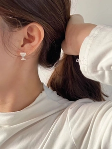 Dettaglio ravvicinato di un orecchino a bottone a forma di calice in argento sterling S925