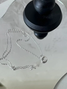 Detail of S925 sterling silver interlocking ring pendant on a delicate bead chain