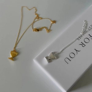 Close-up of minimalist S925 silver goblet necklaces in matte gold and silver finishes