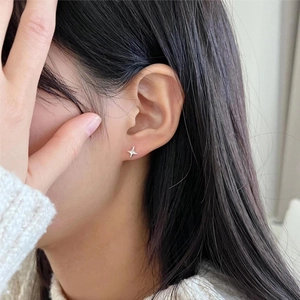 Minimalist S925 sterling silver four-point star stud earrings worn by a model